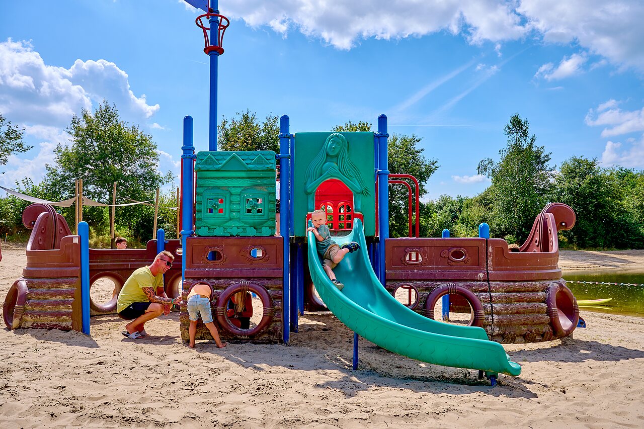 Children playing on pirate playground with slide at CAPFUN Heino campsite.