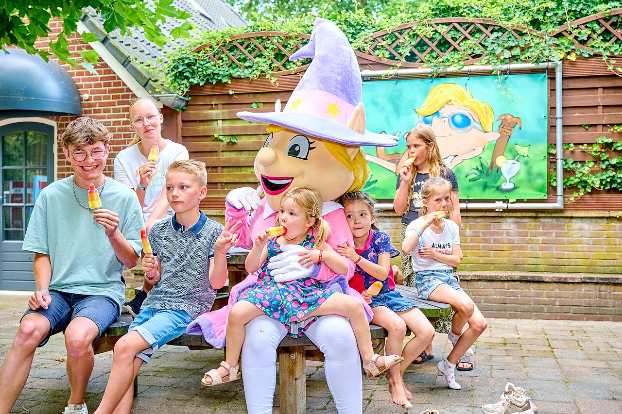 Mascot and smiling children eating popsicles at CAPFUN Heino campsite in Heino.