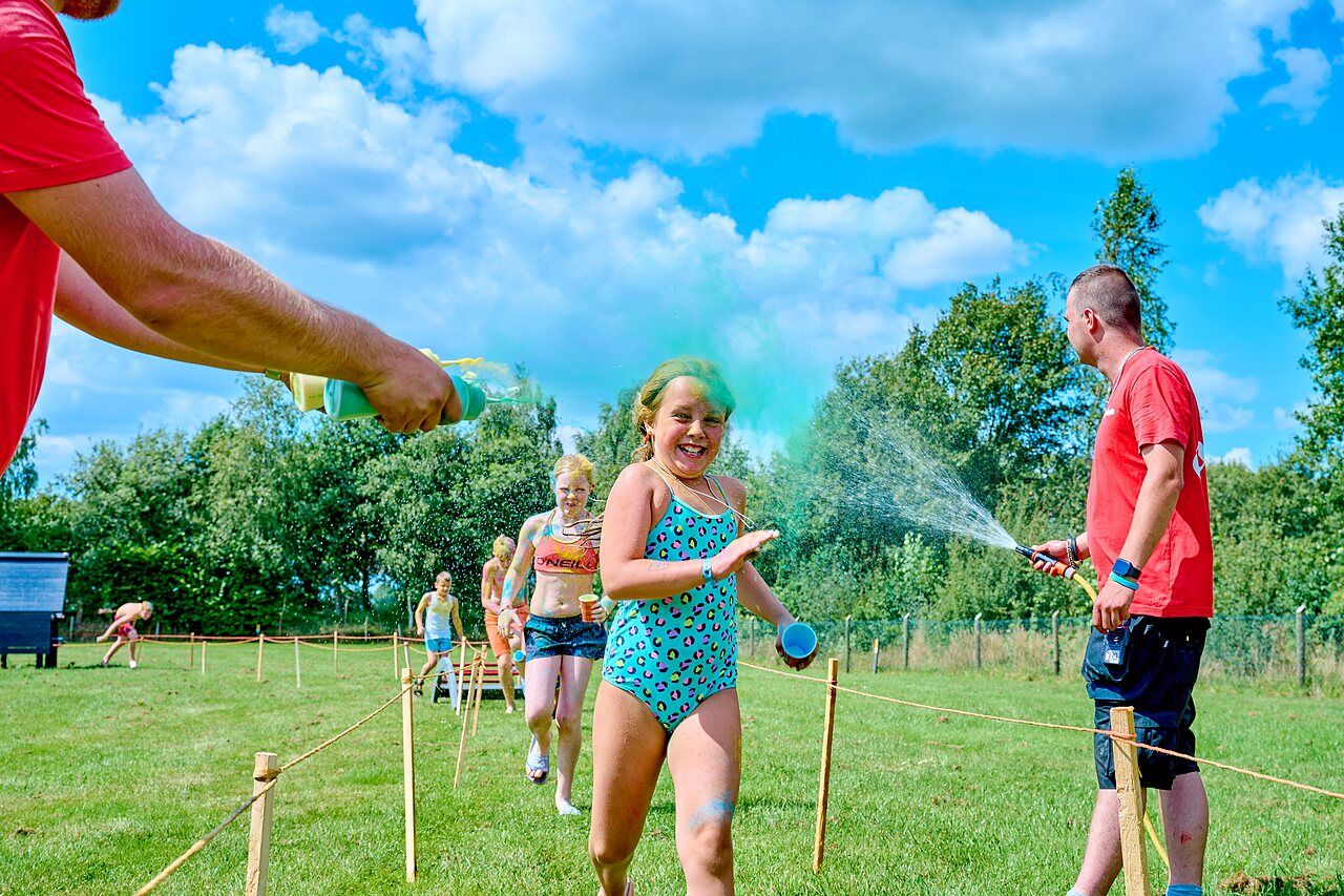 Happy children enjoying color run with water sprays at CAPFUN Heino campsite in Heino.