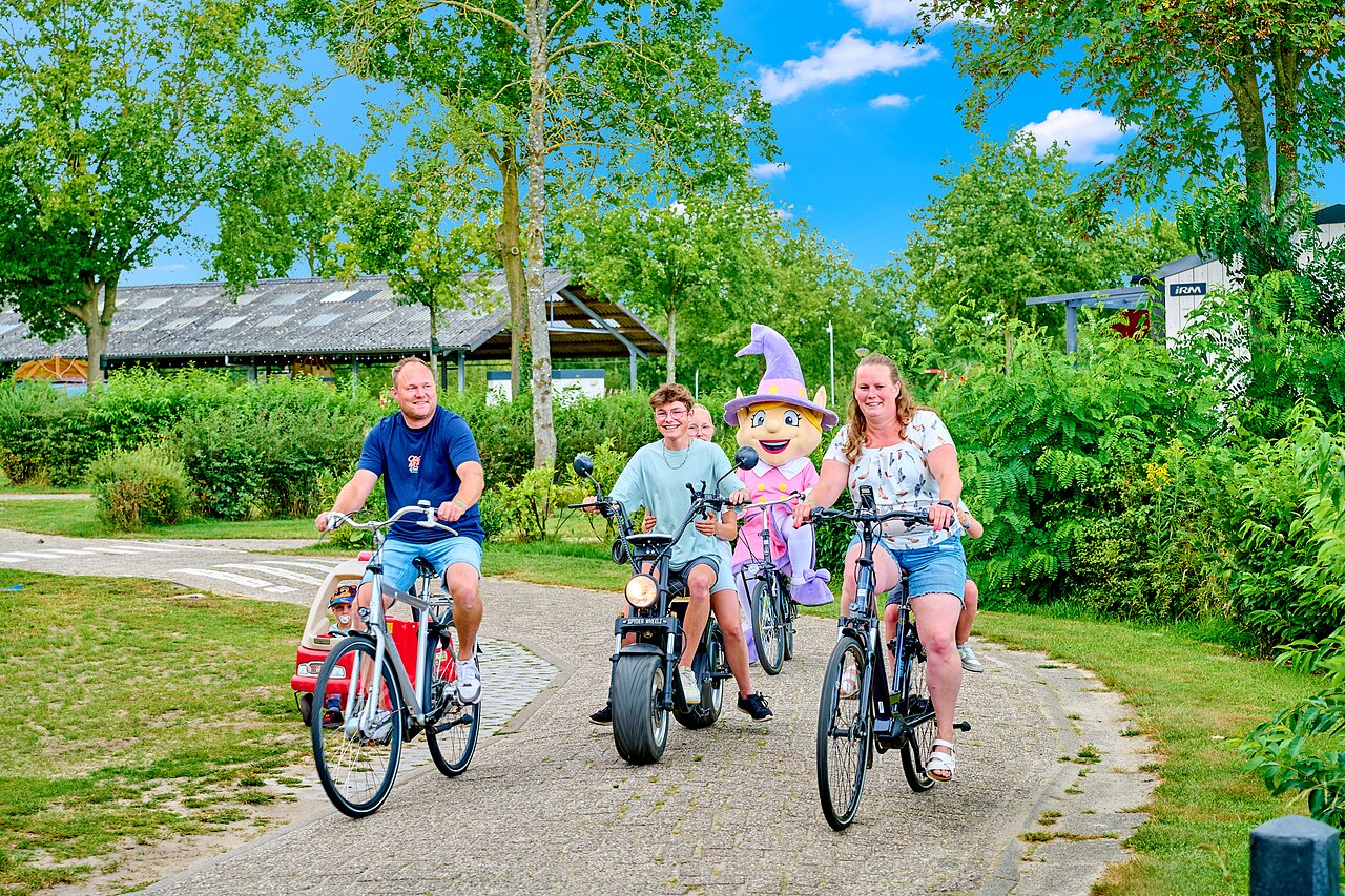 Family and mascot cycling on path at CAPFUN Heino campsite in Heino.
