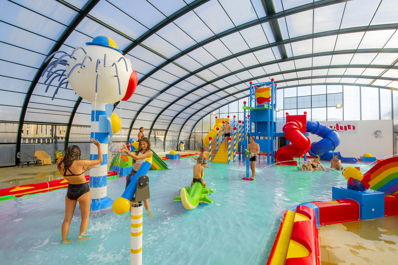Indoor water park with slides and water games at CAPFUN Hirondelle campsite in Oteppe.