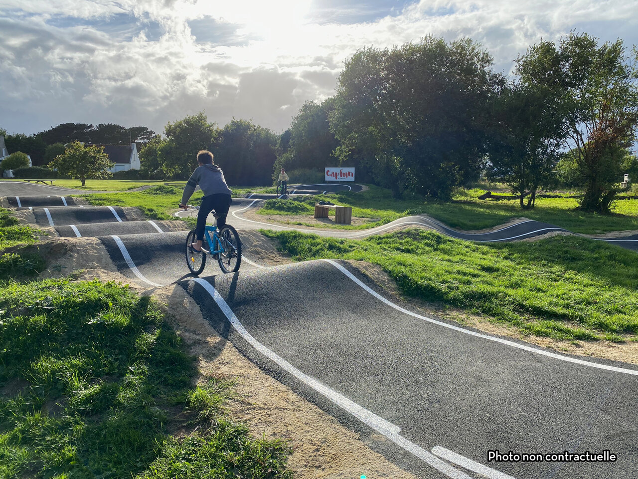 Child on bike on modern pump track at CAPFUN Hirondelle campsite in Oteppe.