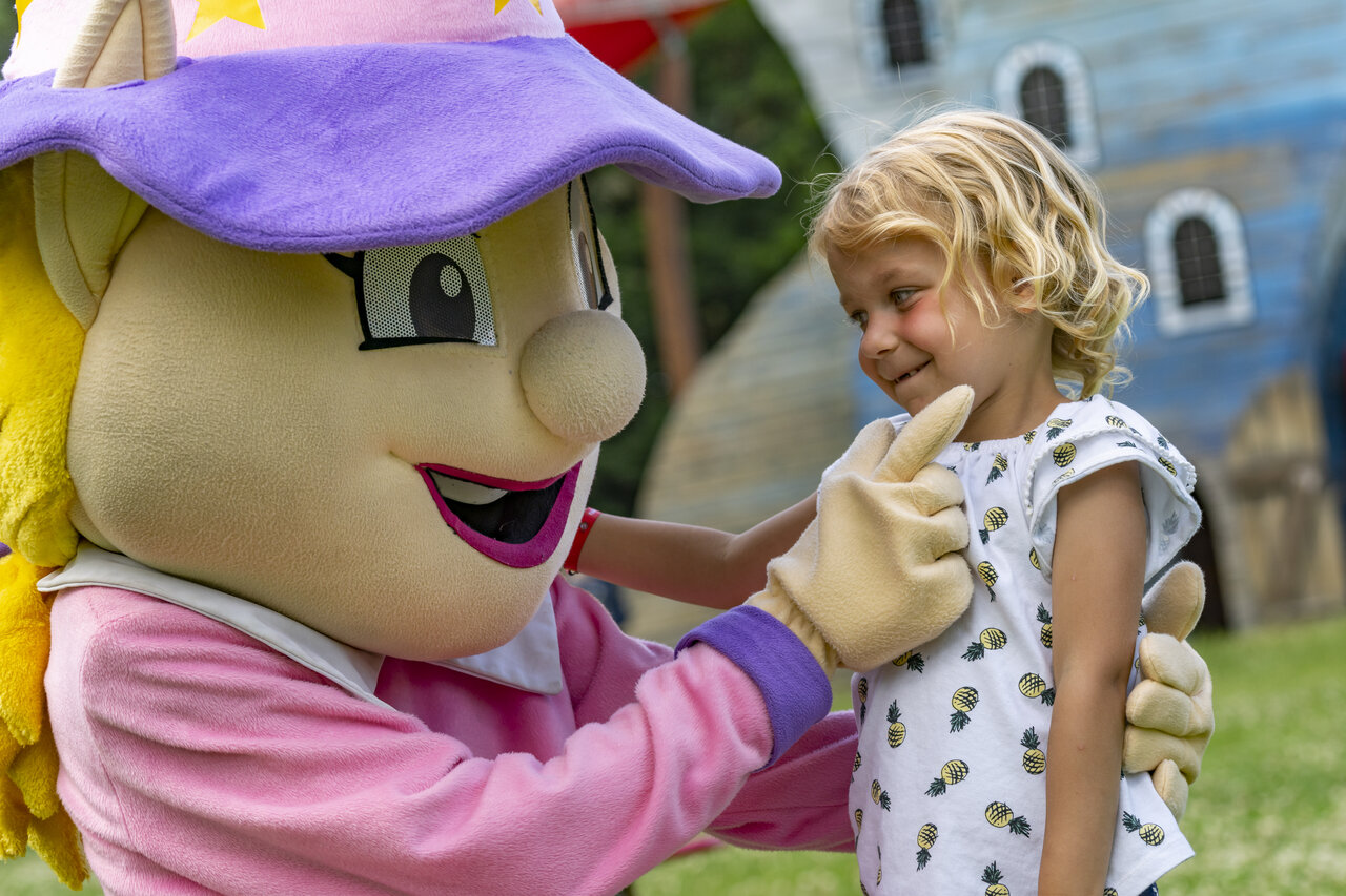 Smiling child with entertainment mascot at CAPFUN Hirondelle campsite in Oteppe.