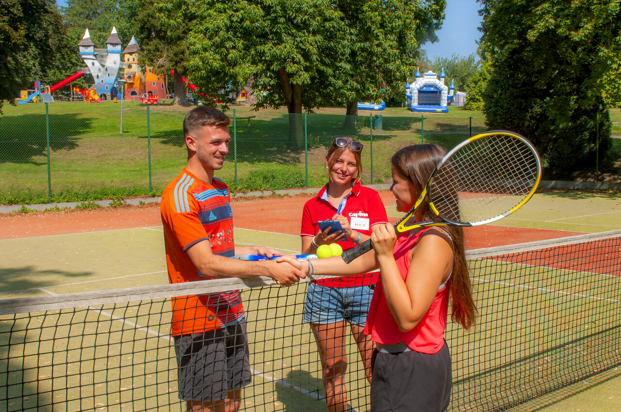 Tennis players and animator on the court at CAPFUN Hirondelle campsite in Oteppe.