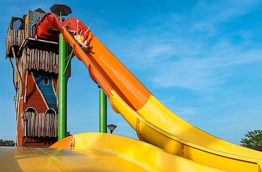 Giant water slide with enthusiastic holidaymakers at CAPFUN Hirondelle campsite in Oteppe.
