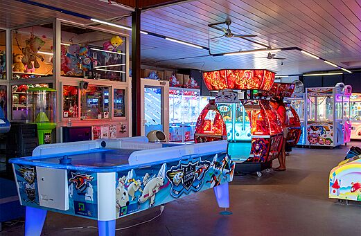 Games room with air hockey and claw machines at CAPFUN Hirondelle campsite in Oteppe.