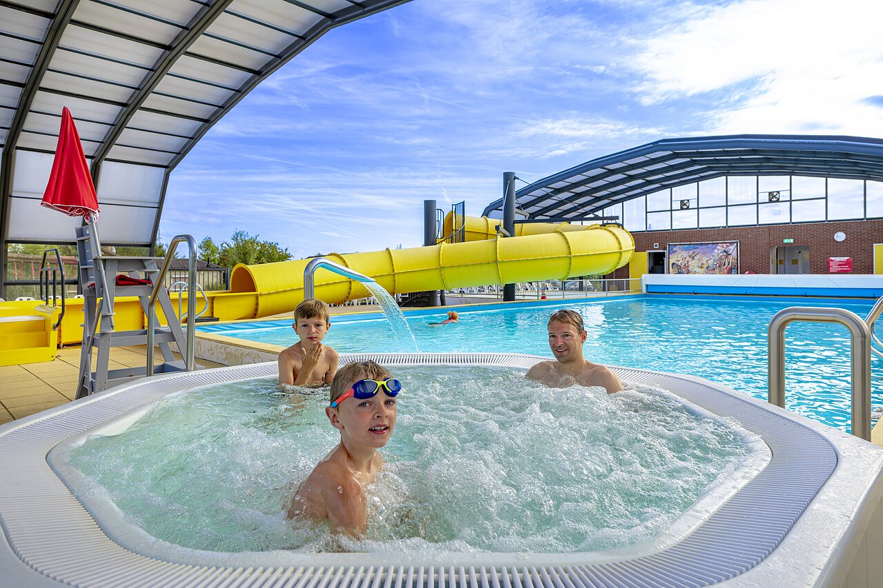 Family in the jacuzzi, giant water slide at CAPFUN IJsselstrand campsite in Doesburg.