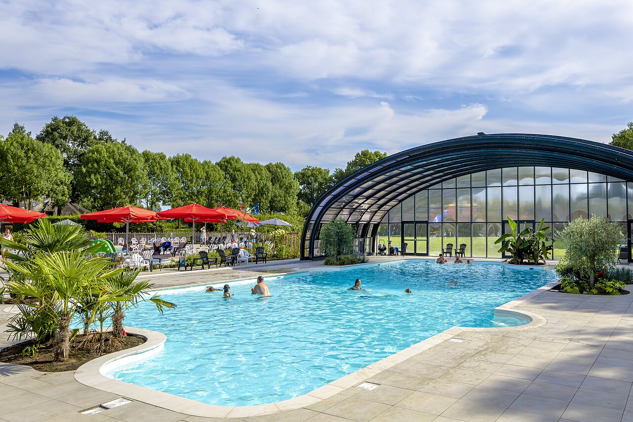 Outdoor swimming pool with covered basin and sun loungers at CAPFUN IJsselstrand campsite in Doesburg.