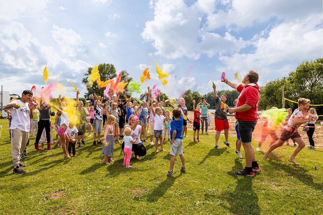 Children and adults enjoying colorful powder animation at CAPFUN IJsselstrand campsite in Doesburg.