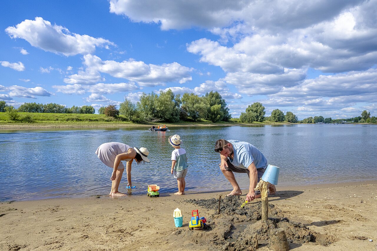 Family with child on sandy beach at CAPFUN IJsselstrand in Doesburg.