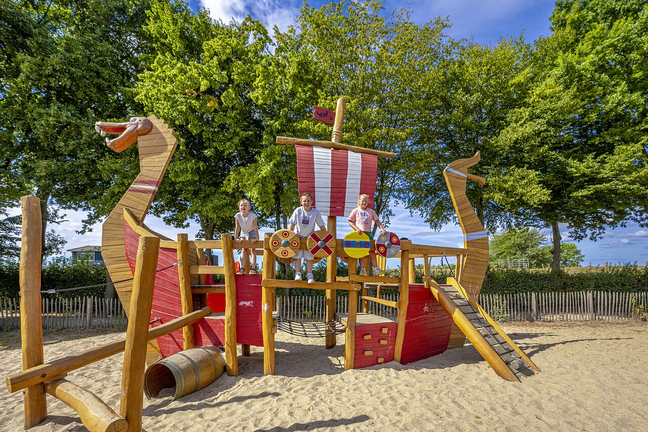 Wooden Viking ship playground with children at CAPFUN IJsselstrand campsite in Doesburg