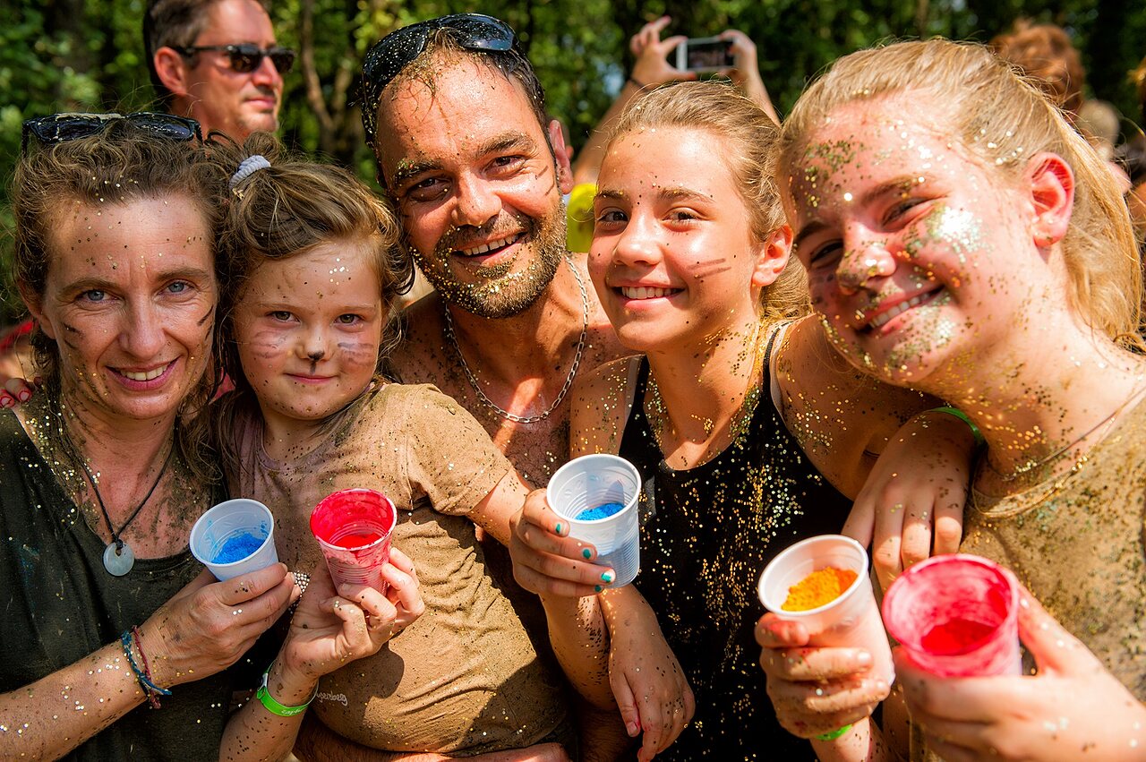 Smiling family covered in glitter during animation at CAPFUN IJsselstrand campsite in Doesburg.