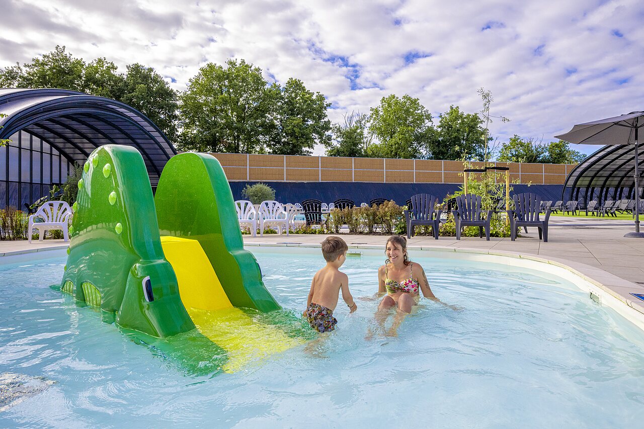 Outdoor pool with crocodile slide, mother and child at CAPFUN IJsselstrand Doesburg.