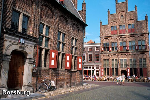 Historic street in Doesburg with brick buildings and lively terraces.
