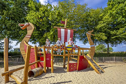 Viking ship playground with children at CAPFUN IJsselstrand campsite in Doesburg.