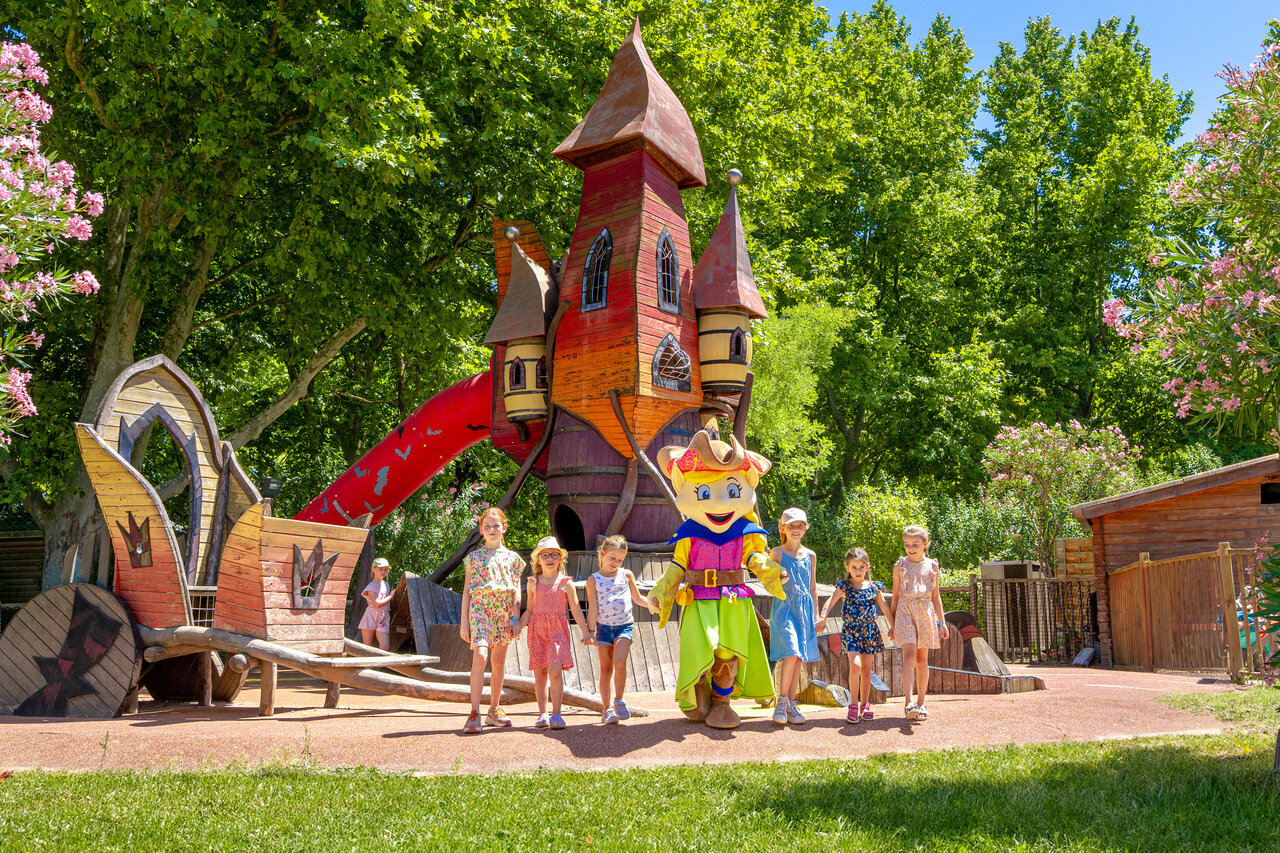 Themed playground with castle, slide, children and mascot at CAPFUN Jantou campsite in LE THOR (84).