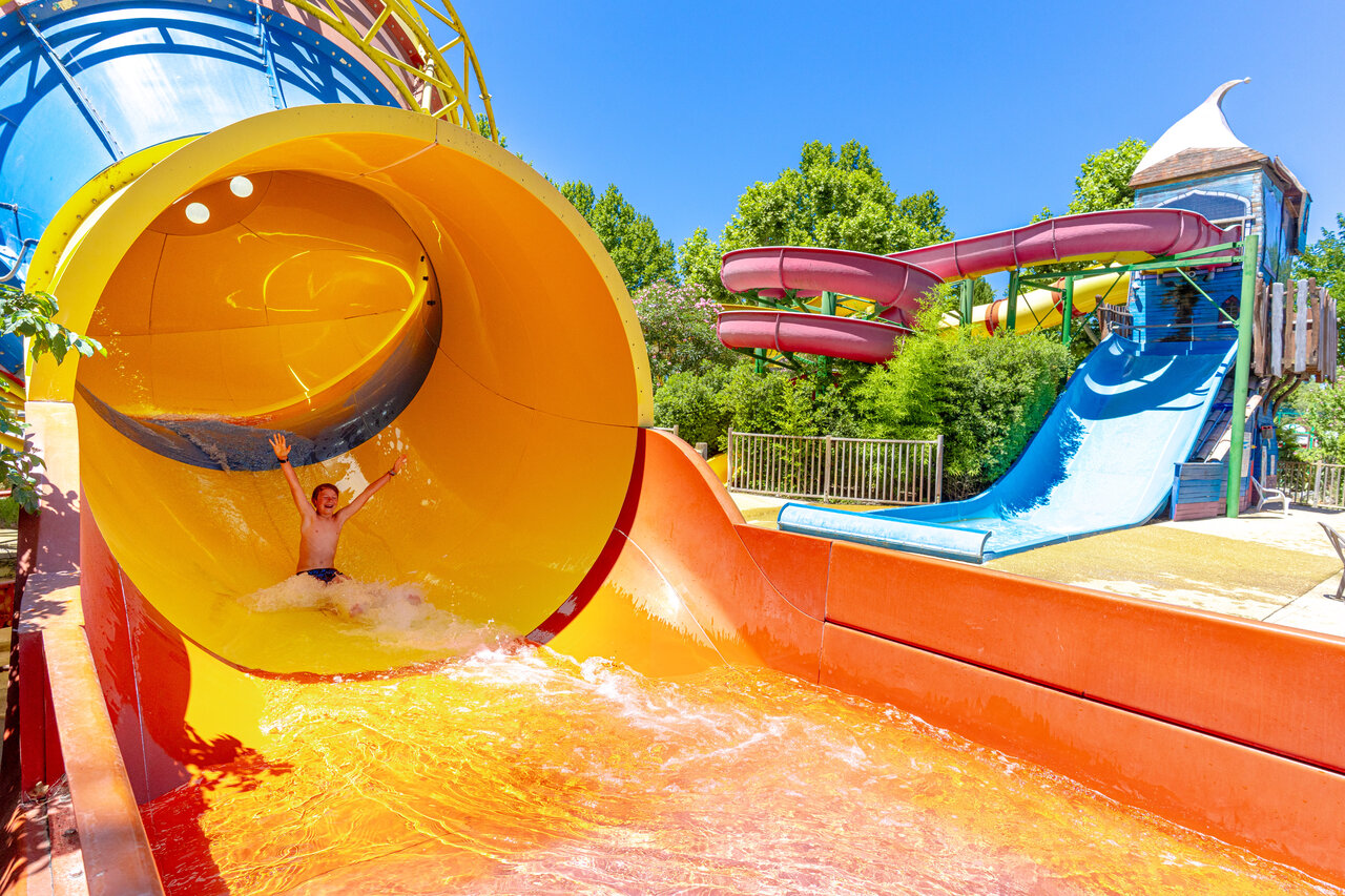 Smiling child sliding down a giant water slide at CAPFUN Jantou campsite in LE THOR (84).