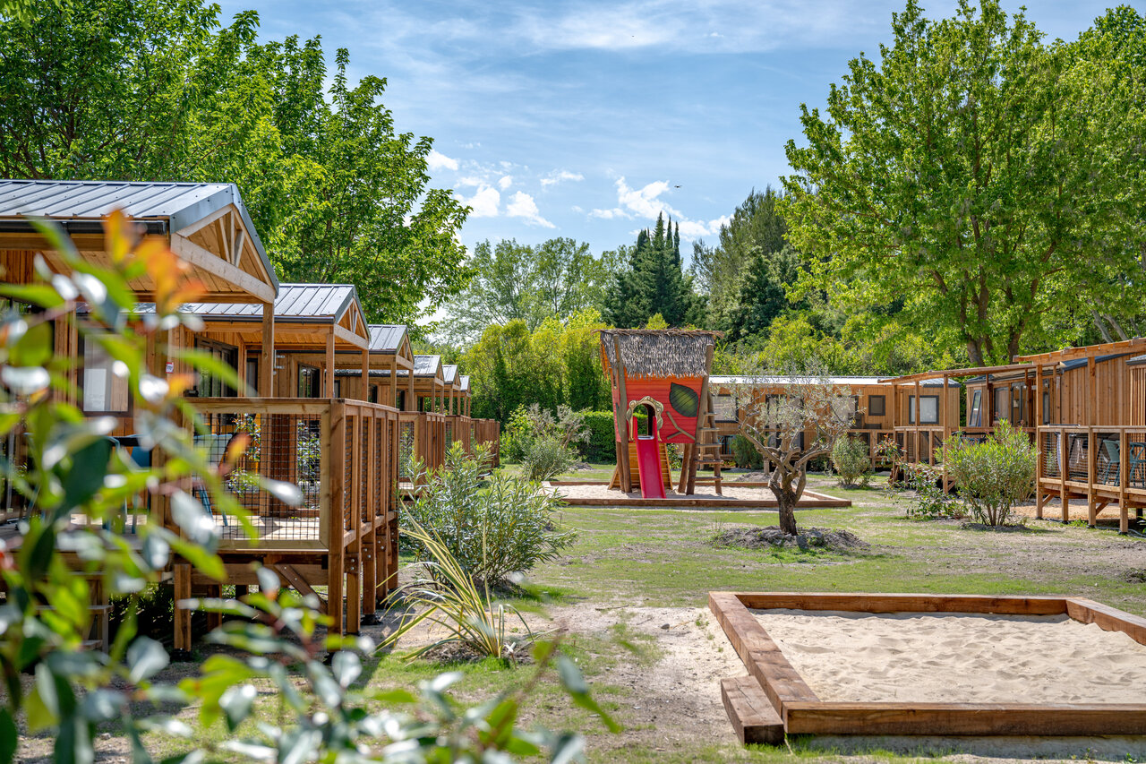 Wooden accommodations, playground, sandbox at CAPFUN Jantou, LE THOR (84).