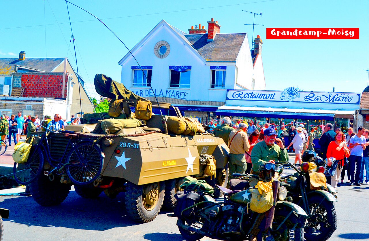 Historic parade with military vehicles in Grandcamp-Moisy, coastal town in Normandy.