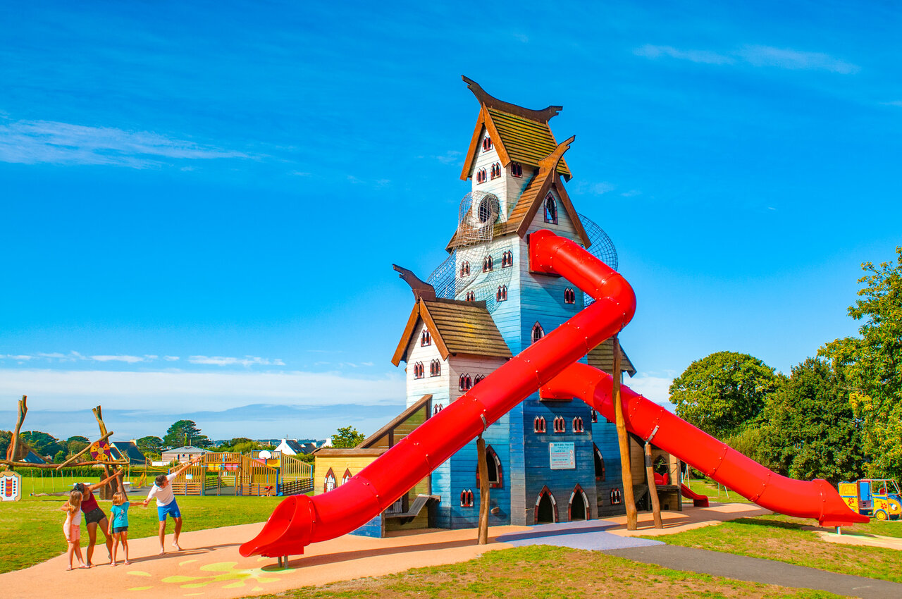 Large play structure with red slides at CAPFUN Kervel campsite in PLONEVEZ PORZAY (29).