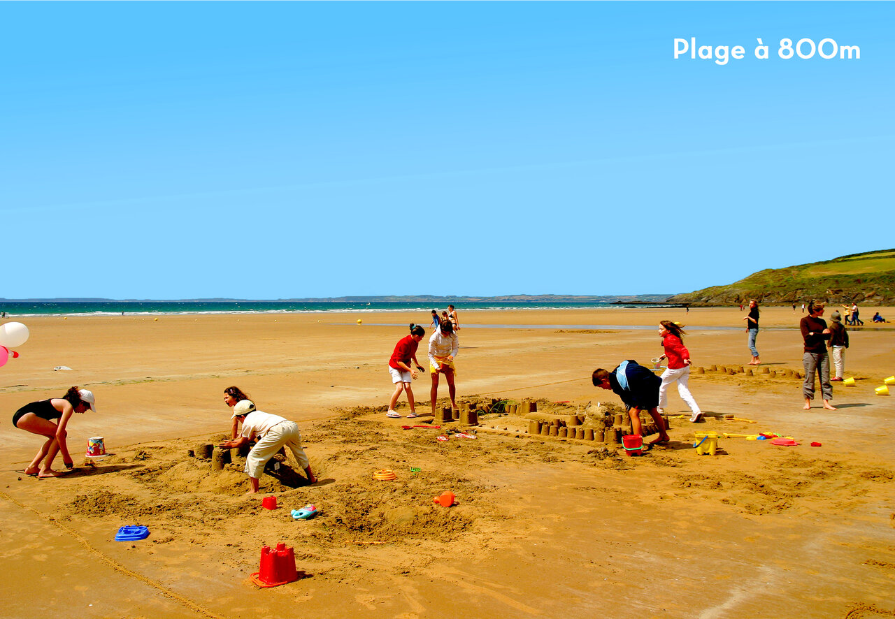 Sandy beach, families building sandcastles. CAPFUN Kervel campsite in PLONEVEZ PORZAY.
