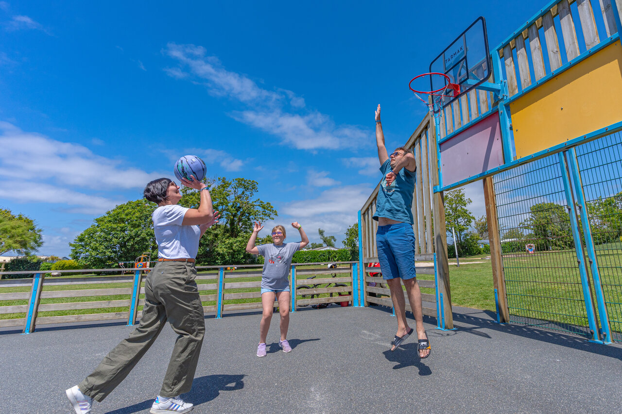 Basketball with family on the multisport court at CAPFUN Kervel campsite.