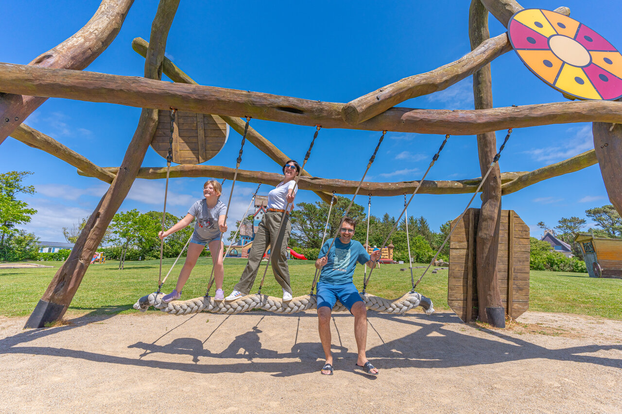 Family enjoying the giant wooden swing at CAPFUN Kervel campsite in PLONEVEZ PORZAY (29).