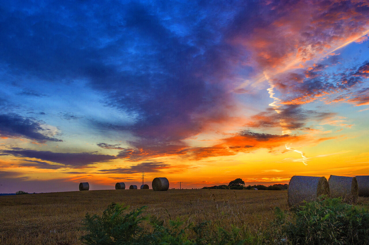 Vibrant sunset over hay field at CAPFUN Kervel campsite in PLONEVEZ PORZAY.