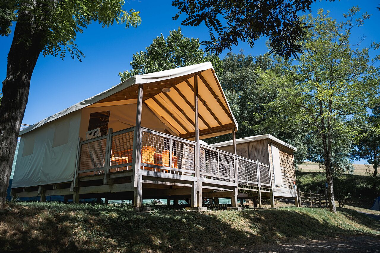 Lodge tent accommodation with terrace, nature at CAPFUN Lac des 3 Vall�es campsite in Lectoure (32).