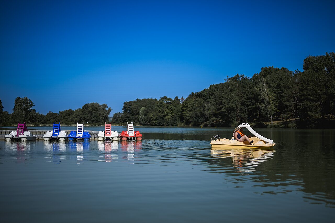 Colorful pedal boats and water activities on the lake at CAPFUN Lac des 3 Vall�es campsite in Lectoure (32).