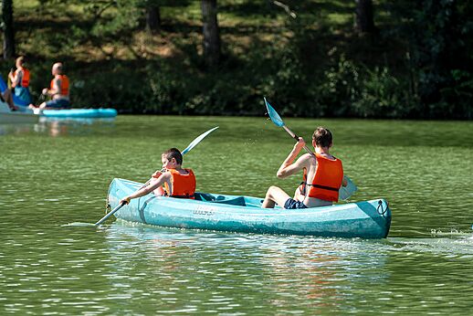 Two people canoeing on the lake at CAPFUN Lac des 3 Vall�es campsite.