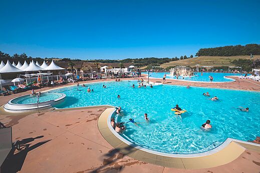Outdoor swimming pool, jacuzzi and waterfall at CAPFUN Lac des 3 Vall�es campsite.