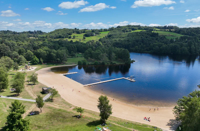Sandy beach, equipped lake and children's playground at CLICOCHIC Lac de Miel campsite in Beynat (19).