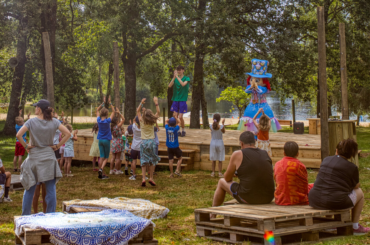 Children's entertainment with animator and mascot on stage at CLICOCHIC Lac de Miel campsite in Beynat (19).