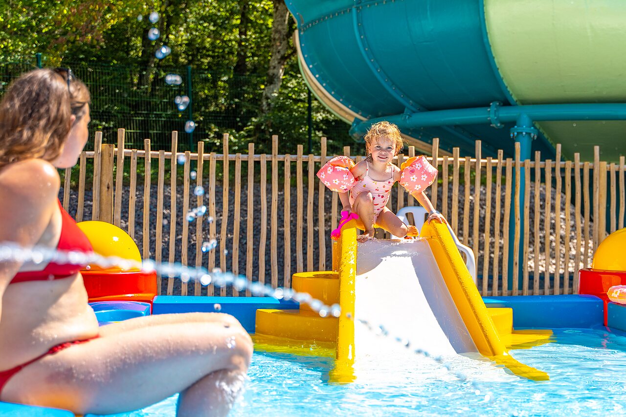Little girl on water slide in children's pool at VAGUES OCEANES Lac de Panthier campsite in Vandenesse-en-Auxois (21).