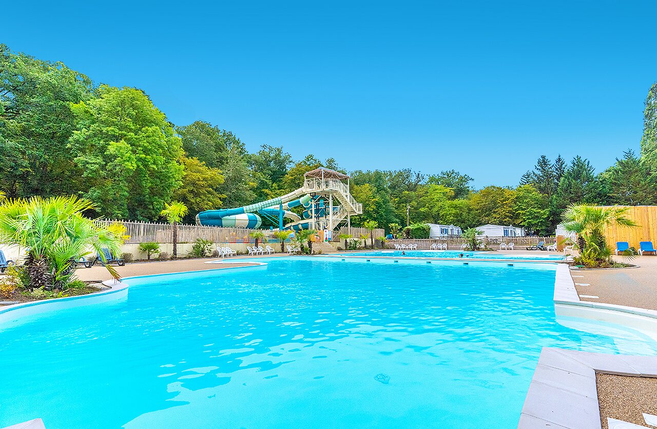 Outdoor swimming pool, waterslides and Mobile-homes at VAGUES OCEANES Lac de Panthier campsite.
