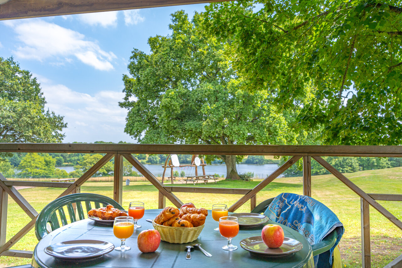 Breakfast on accommodation terrace, lake view, at CAPFUN Lac de Ribou in Cholet.
