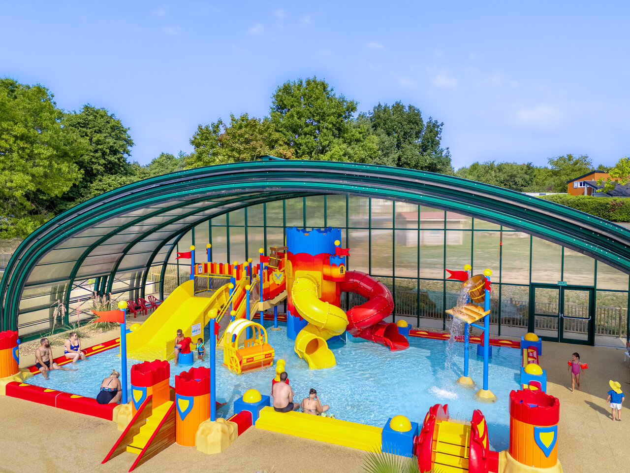 Covered water play area with colorful slides at CAPFUN Lac de Ribou campsite in Cholet (49).
