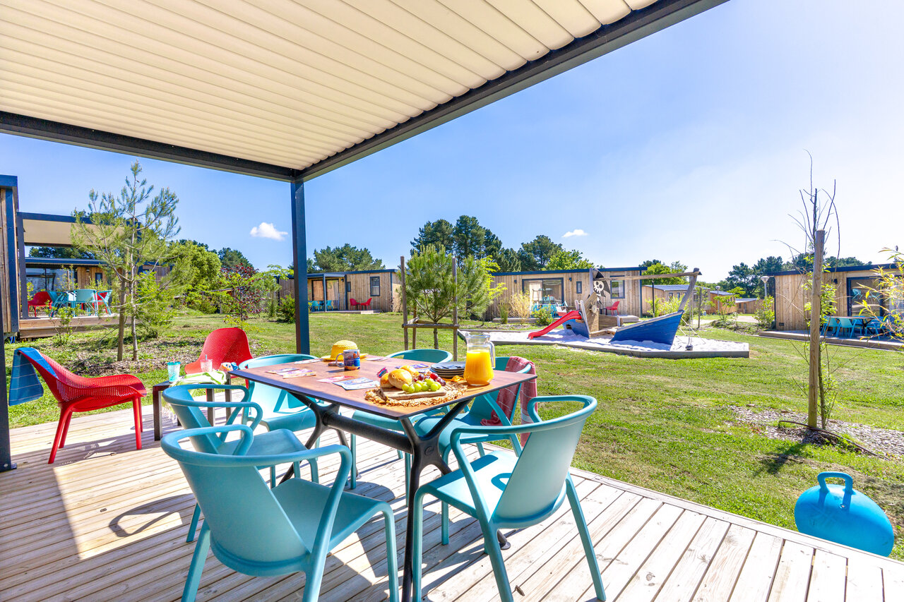 Covered mobile home terrace, children's playground at CAPFUN Lac de Ribou campsite in Cholet (49).