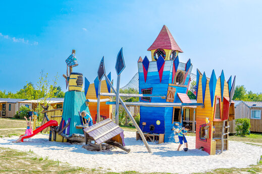 Colorful castle-themed playground with slide at CAPFUN Lac de Ribou campsite in Cholet (49).