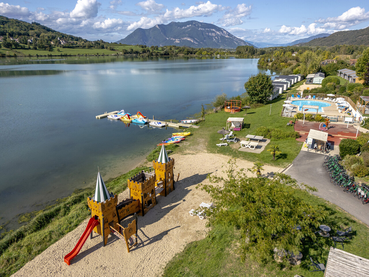 Castle playground, lake, swimming pool at CLICOCHIC campsite Massignieu-de-Rives.
