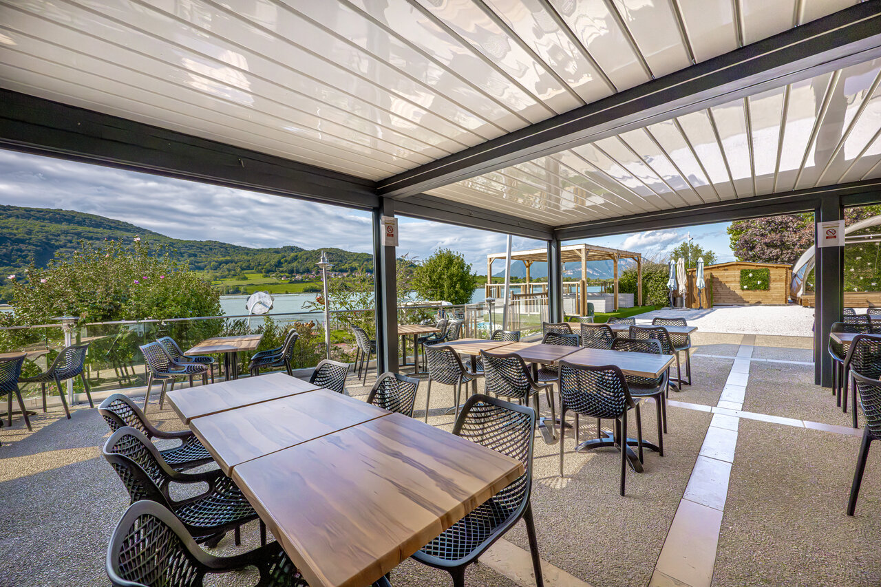 Shaded restaurant terrace, lake view, at CLICOCHIC Lac du Lit du Roi.