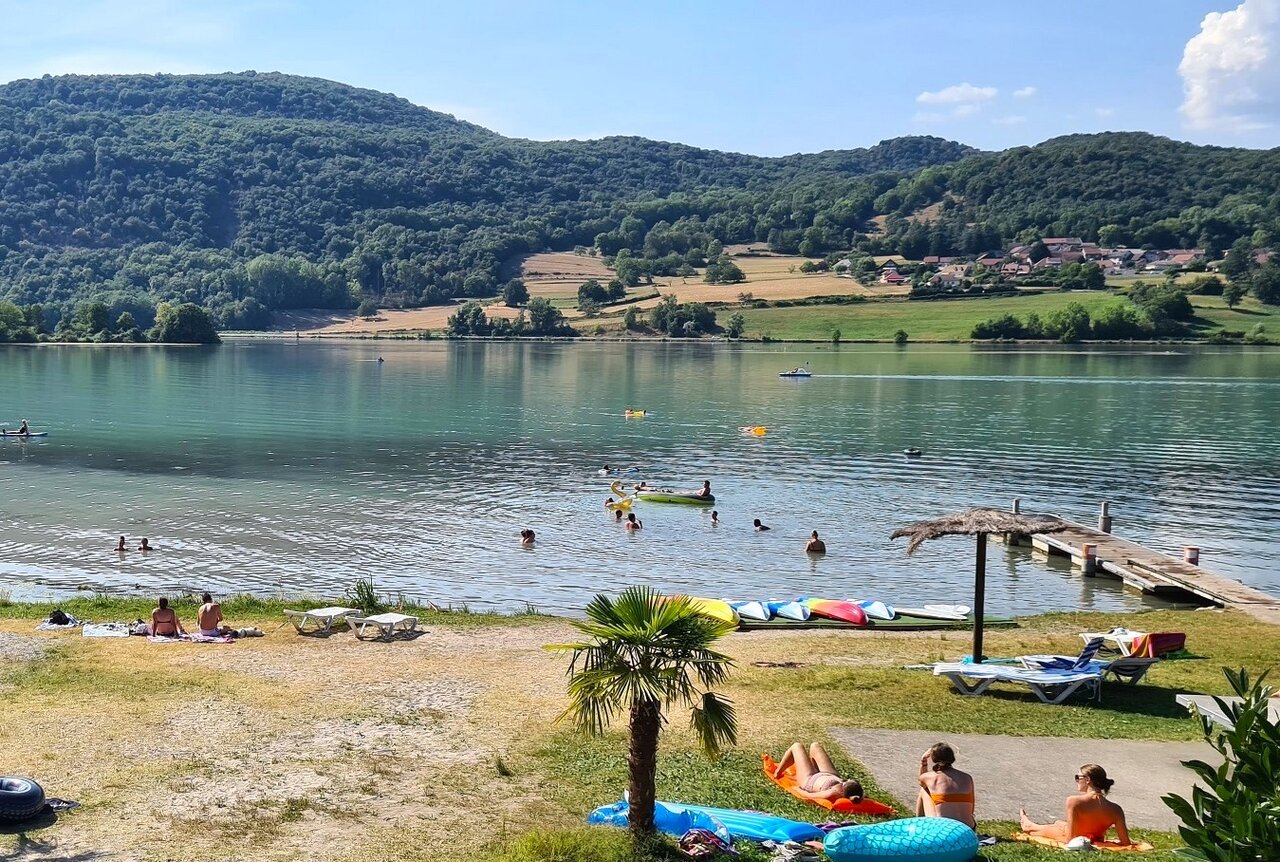 Lake beach, swimming and water activities at campsite CLICOCHIC Lac du Lit du Roi in Massignieu-de-Rives (01).