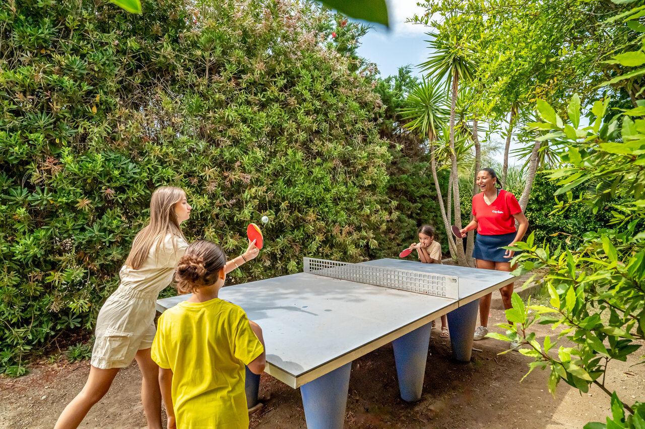 Family playing outdoor table tennis at CAPFUN Las Bousigues campsite in Le Barcar�s (66).