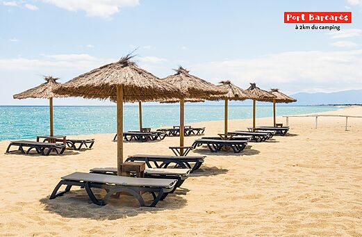 Sandy beach with straw umbrellas and chairs near Port Barcar�s, Occitania.