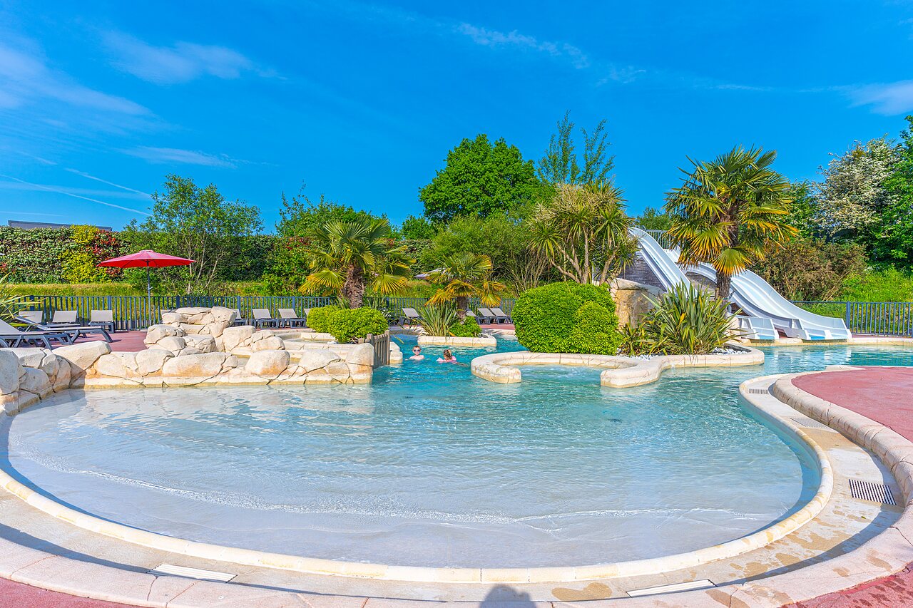 Outdoor pool, slides, kids' area at VAGUES OCEANES Les Iles campsite in Hudimesnil (50).