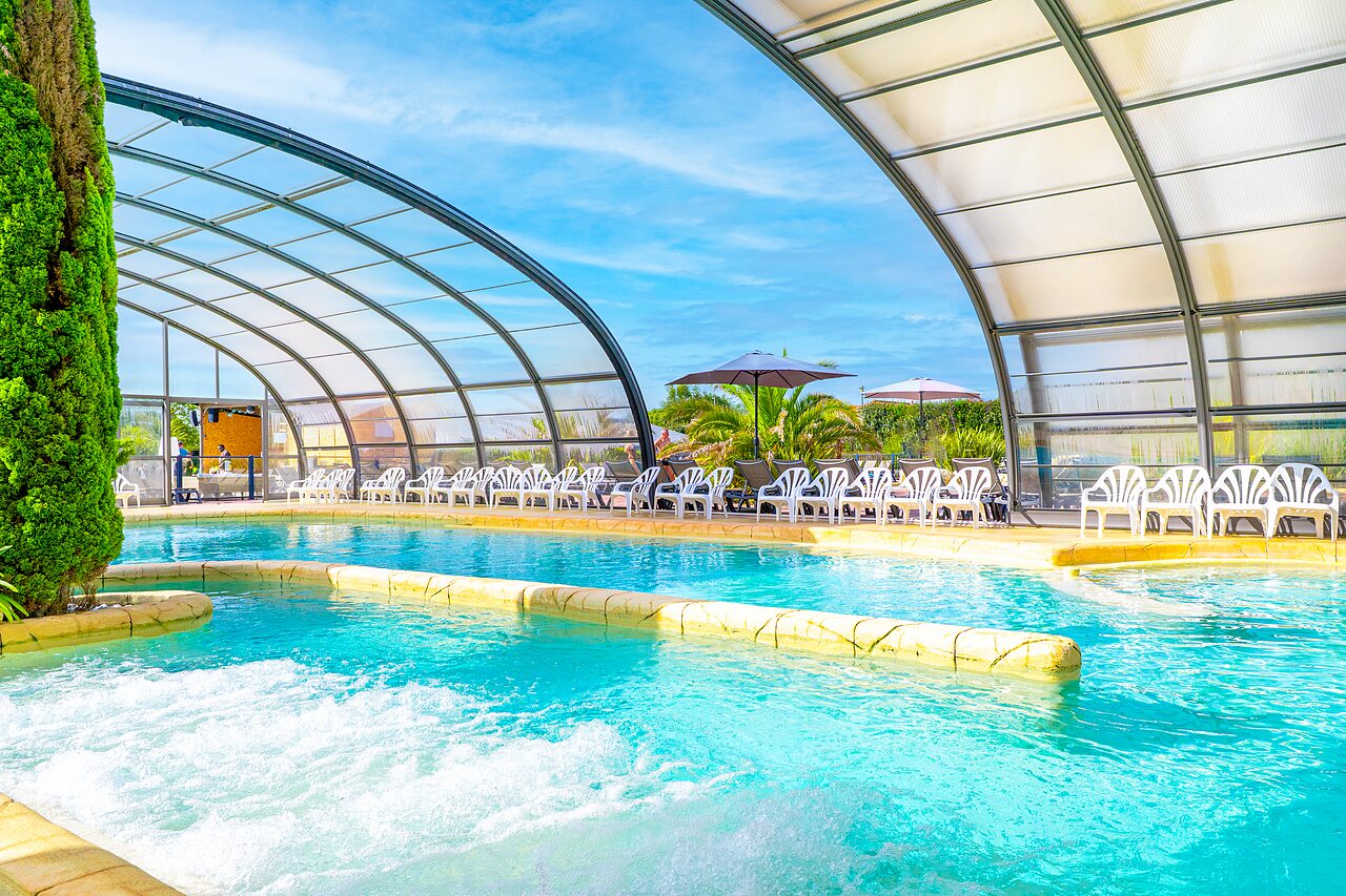 Covered swimming pool, jacuzzi, sun loungers at VAGUES OCEANES Les Iles campsite (50).