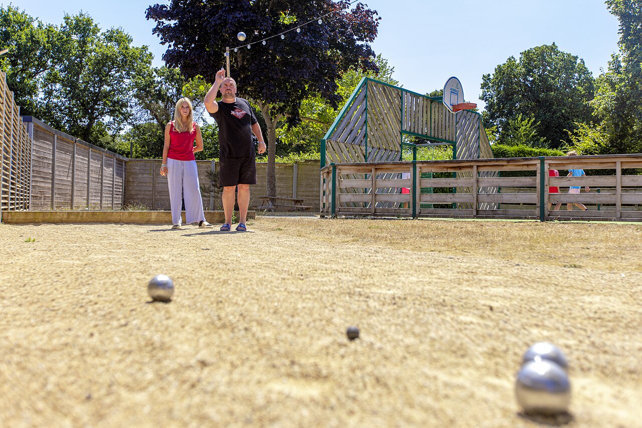 Petanque court with players at CLICOCHIC Bellevue d'Erquy campsite (22).