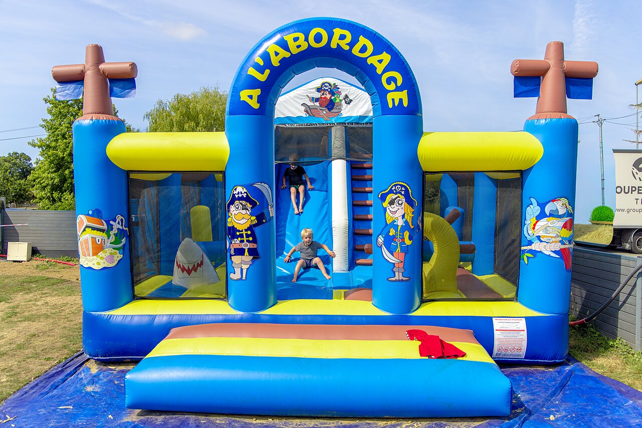 Inflatable pirate bouncy castle with slide for children at CLICOCHIC Bellevue d'Erquy campsite.