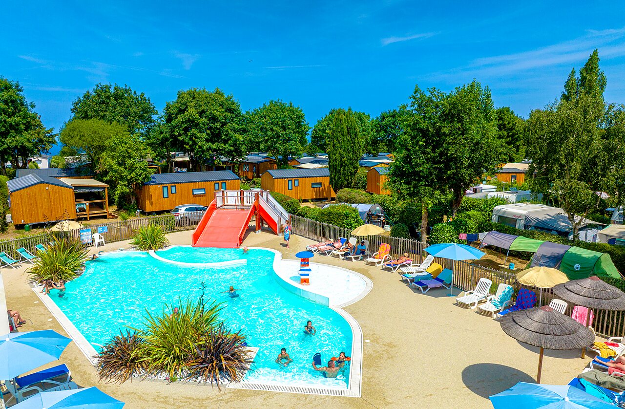 Outdoor swimming pool, water slide and Mobile homes at CLICOCHIC Bellevue campsite, Erquy.